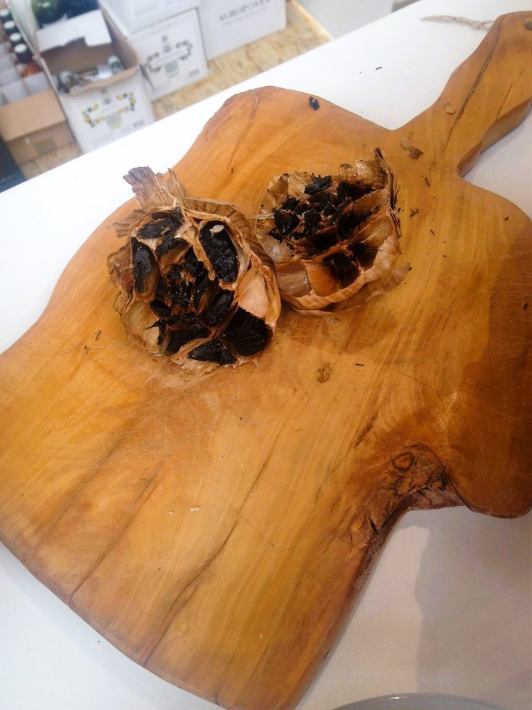 Black fermented garlic displayed on an olive wood cutting board. This is a true specialty of the Croatian cuisine produced near Zagreb.