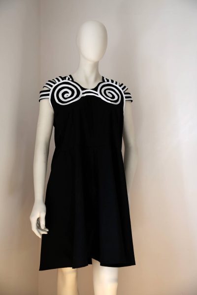 Black sleeveless bathing suit designed by Emilie Flöge, displayed on a mannequin, with a loose knee-length silhouette and bold white spiral and striped decoration across the shoulders and neckline.